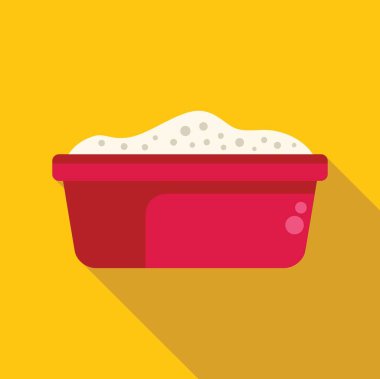 Kırmızı leğen, sarı arka planda kirli çamaşırlar için sabunlu suyla dolu.