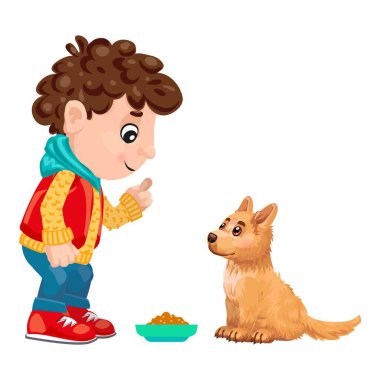 Genç çocuk bir kase köpek mamasına işaret ediyor, köpeğine beklemeyi öğretiyor.
