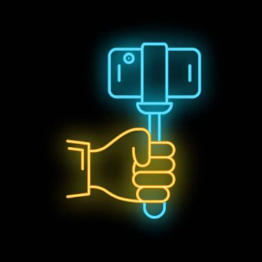 Parlak neon tabela siyah arka planda fotoğraf çeken akıllı telefonlu bir selfie çubuğunu temsil ediyor.