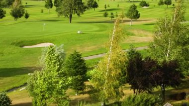 Ağaçları ve güçlü rüzgarları olan güzel bir manzara ve golf sahası. Bulgaristan 'da güçlü rüzgarla golf sahası.