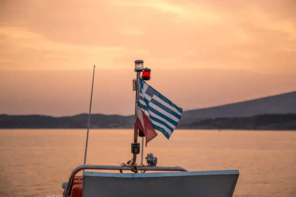 View of a Greek flag with the sunset in the background in Athens, Greece
