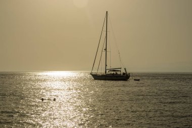 Günbatımında küçük tekne ve yatlar Yunanistan 'da okyanus manzaralı marina parkına demirledi.