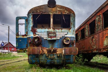 Eski paslı elektrikli çoklu tren kullanımdan kaldırıldı ve yeşil çimenlik alana demiryolu kenarında terk edildi. 