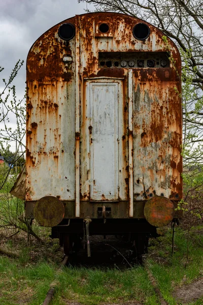 旧的生锈的运货马车废弃在铁路边沿上 青草丛生 — 图库照片