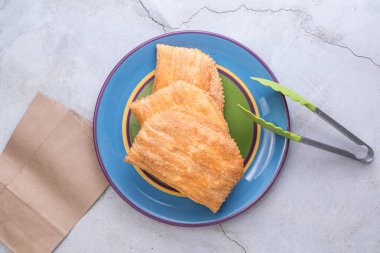 Three Jamaican beef patties on a large colourful plate clipart