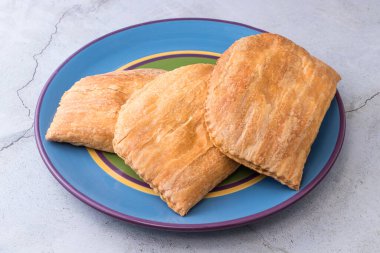 Büyük renkli bir tabakta üç Jamaika köftesi.