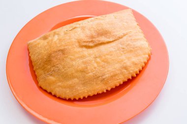 Jamaika usulü sığır etli köfteyi bir tabakta beyaz arka plana yakın tut.