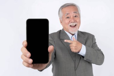 Asian senior businessman , old man with suit feel happy pointing finger to big smart phone with blank screen , white screen isolated on white background - smart phone empty display Mock Up Image