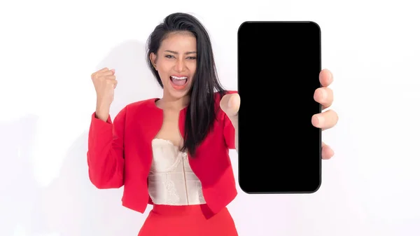 赤いドレスの美しいアジアのブルネットの女性かわいい少女 白い背景で隔離された白いスクリーンが付いている大きいスマートな電話を示す興奮した驚きの女の子 表示モックアップイメージ — ストック写真
