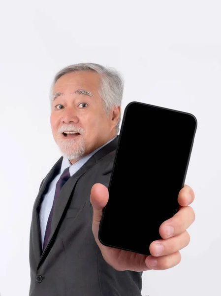 アジアの高級ビジネスマン スーツを着た老人は 白い背景に隔離された黒い画面で大きなスマートフォンに指を指して幸せを感じる スマートフォンの空のディスプレイ Mock Image — ストック写真