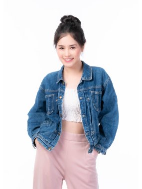 Gülümseyen, kot ceketli, sıradan giyinmiş, beyaz arka planda bir stüdyoda rahatça poz veren Asyalı güzel bir kadın.