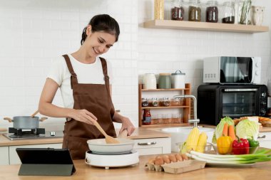 Gülümseyen Genç Kadın Modern Mutfakta Pişirme, Önlük Giyme ve Tarifi İçin Tablet Kullanma, Taze Sebze ve İçindekiler, Sağlıklı Yaşam Tarzı ve Ev Pişirme Konsepti