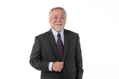 Kendine güvenen ve gülümseyen koyu takım elbiseli bir Asyalı işadamı, beyaz bir arka plana karşı duruyor, profesyonellik ve deneyimi yansıtıyor.