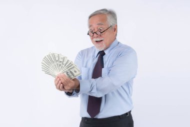 Mutlu Asya 'lı kıdemli işadamı heyecanlı bir yüz ifadesi olan Amerikan doları banknotlarını tutuyor, beyaz arka planda izole edilmiş, finansal başarı, zenginlik ve para kavramı