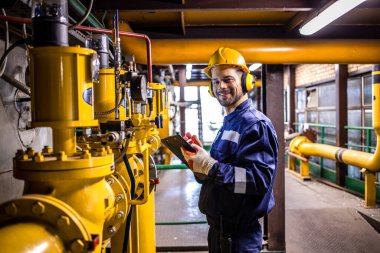 Portrait of heating plant technician checking natural gas installations and pipes.