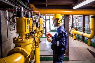 Professional oil and gas refinery worker working in energy production factory.
