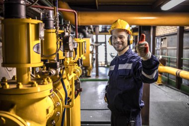 Power generation plant worker controlling crude oil and gas processing.