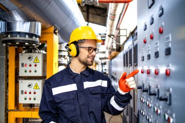 Factory worker operating industrial machine inside power plant.