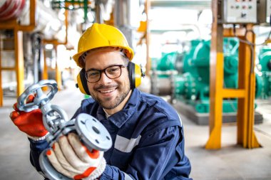Factory plumber or technician holding brand new metal industrial valve inside water processing factory.
