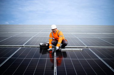 Top view of solar energy worker installing photovoltaic panels on the roof.