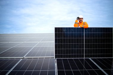 Portrait of worker holding solar panel inside power plant.