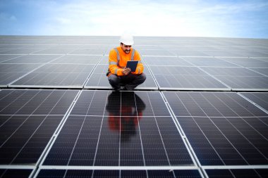 Solar energy industrial worker doing quality control of photovoltaic panels installed on the factory. New solar technologies.
