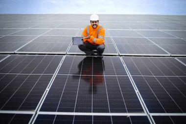Solar energy industrial worker doing quality control of photovoltaic panels installed on the factory. New solar technologies.