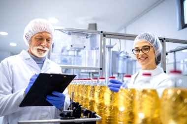 Food factory workers or technologists doing quality control of the product in production plant. clipart