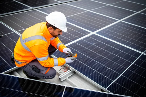 Experienced solar energy worker installing solar panels for renewable power plant.