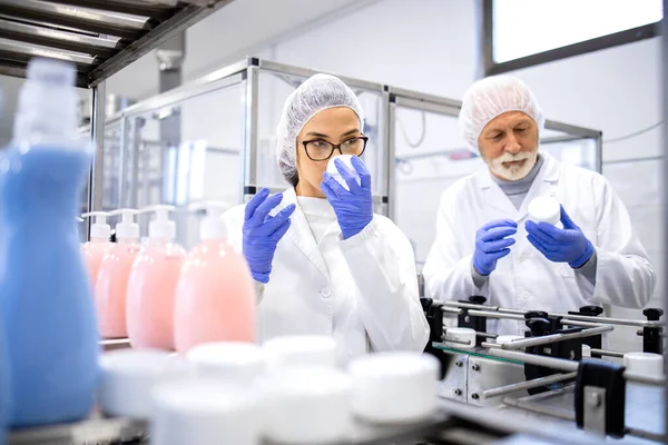 Cosmetics factory workers checking smell and quality of new body care products.