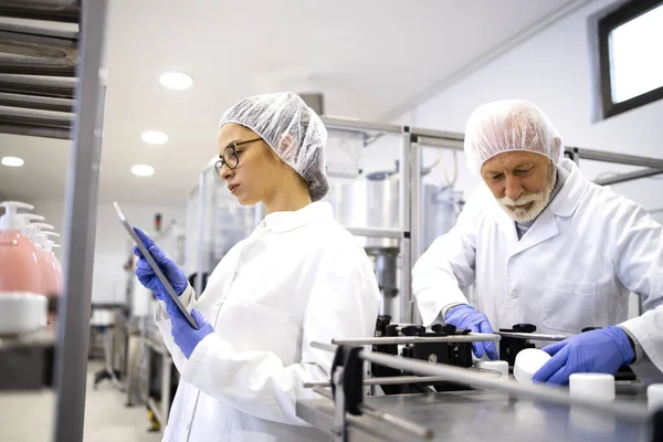 コンベヤマシンに立つ工場労働者と製薬業界向け化粧品製品の製造管理 — ストック写真