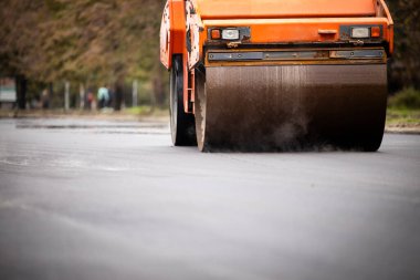 Asphalt paving machine working on new road construction.