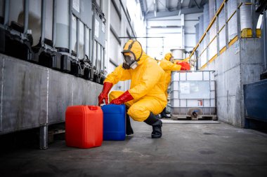 Workers in zinc galvanizing production plant filling canisters with necessary chemicals and acids.