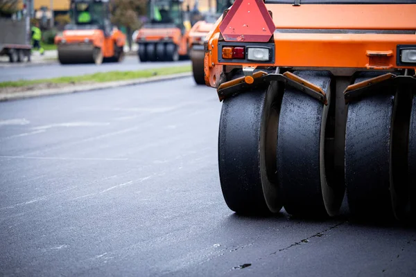 Road construction and asphalting machinery in action.