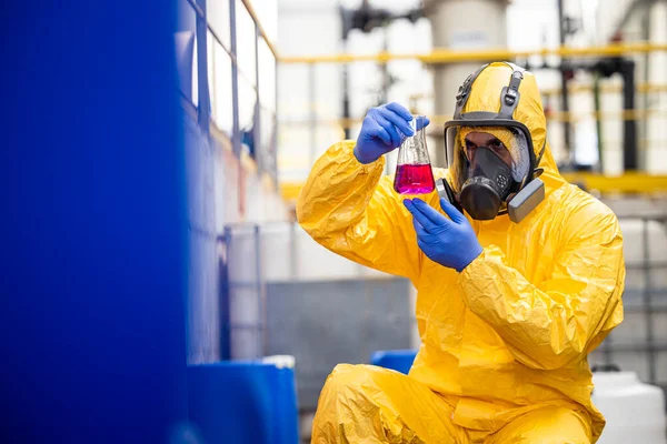 stock image Chemical worker in hazmat protection suit and gas mask inspecting and doing quality control of chemicals inside production plant.