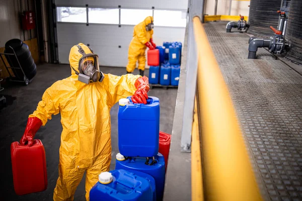 stock image Workers in yellow protection suit and gas mask preparing acids and chemicals for metal manufacturing industry.