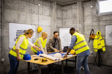Bir grup mimar ve inşaat mühendisi inşaat sahasında toplanıp inşaat fabrikasını analiz edecekler ve proje hakkında konuşacaklar..