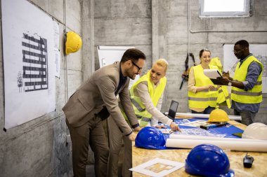 Tecrübeli mimar ve mühendislerden oluşan bir ekip fikirleri paylaşıyor ve inşaat alanındaki fabrikayı inceliyor..