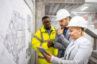 İnşaat sahasında birlikte çalışan ve proje planı ya da planı tartışan yapı mühendislerinden oluşan bir ekip..