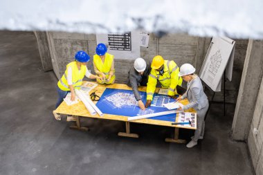 Fikir ve proje planlarını paylaşan deneyimli mimarlar, mühendisler ve işçilerden oluşan inşaat iç mimarisi ve ekibi.