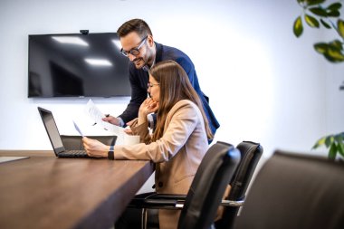 Ofiste birlikte çalışan iş elbiseli pozitif genç insanlar..