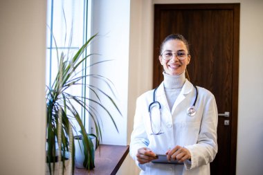 Hastane ofisinde steteskoplu gülümseyen kadın doktorun portresi..