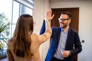 İş adamları birbirlerini selamlıyor ve başarılı bir toplantıdan sonra beşlik çakıyorlar..