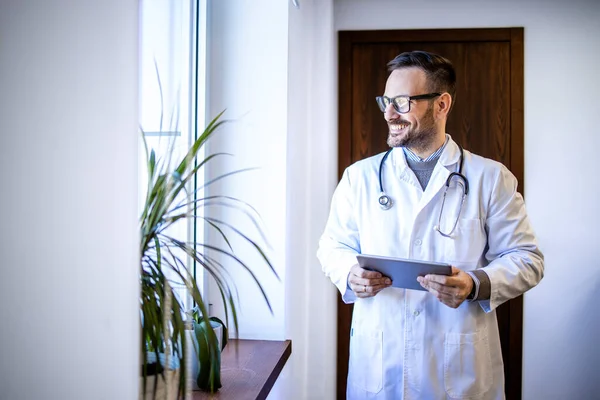 Doświadczony Lekarz Białym Mundurze Stetoskopie Patrzący Przez Okno Szpitala — Zdjęcie stockowe