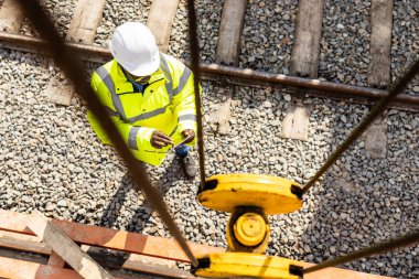 Endüstri taşımacılığı. İşçi işleten vinç ve kargo treni boşaltılıyor.