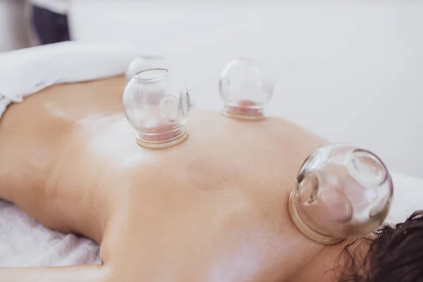 Hijama therapy with heated vacuum cups on patient skin to heal pain problems.