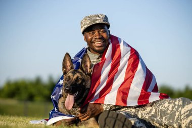 Askeri köpeğini kucaklayan üniformalı gülümseyen askerin portresi. İkisi de Amerikan bayrağıyla kaplıydı. Amerika Kahramanları.