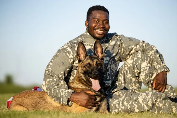 Portrait of smiling soldier and trained military dog.