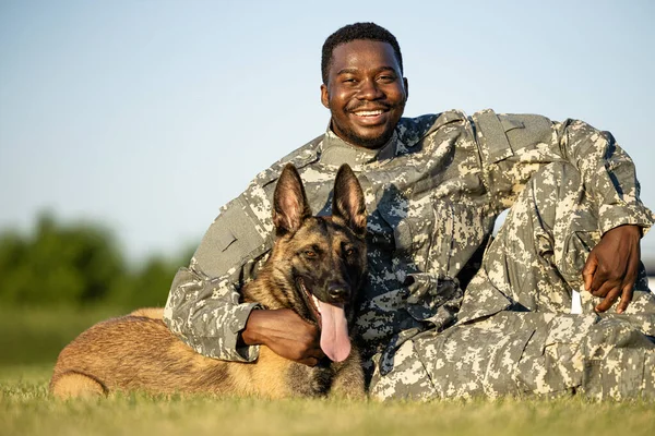 Portrait of cheerful soldier and trained military dog.