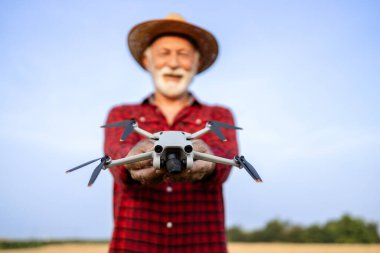 Tarlada tarımsal drone tutan çiftçi.